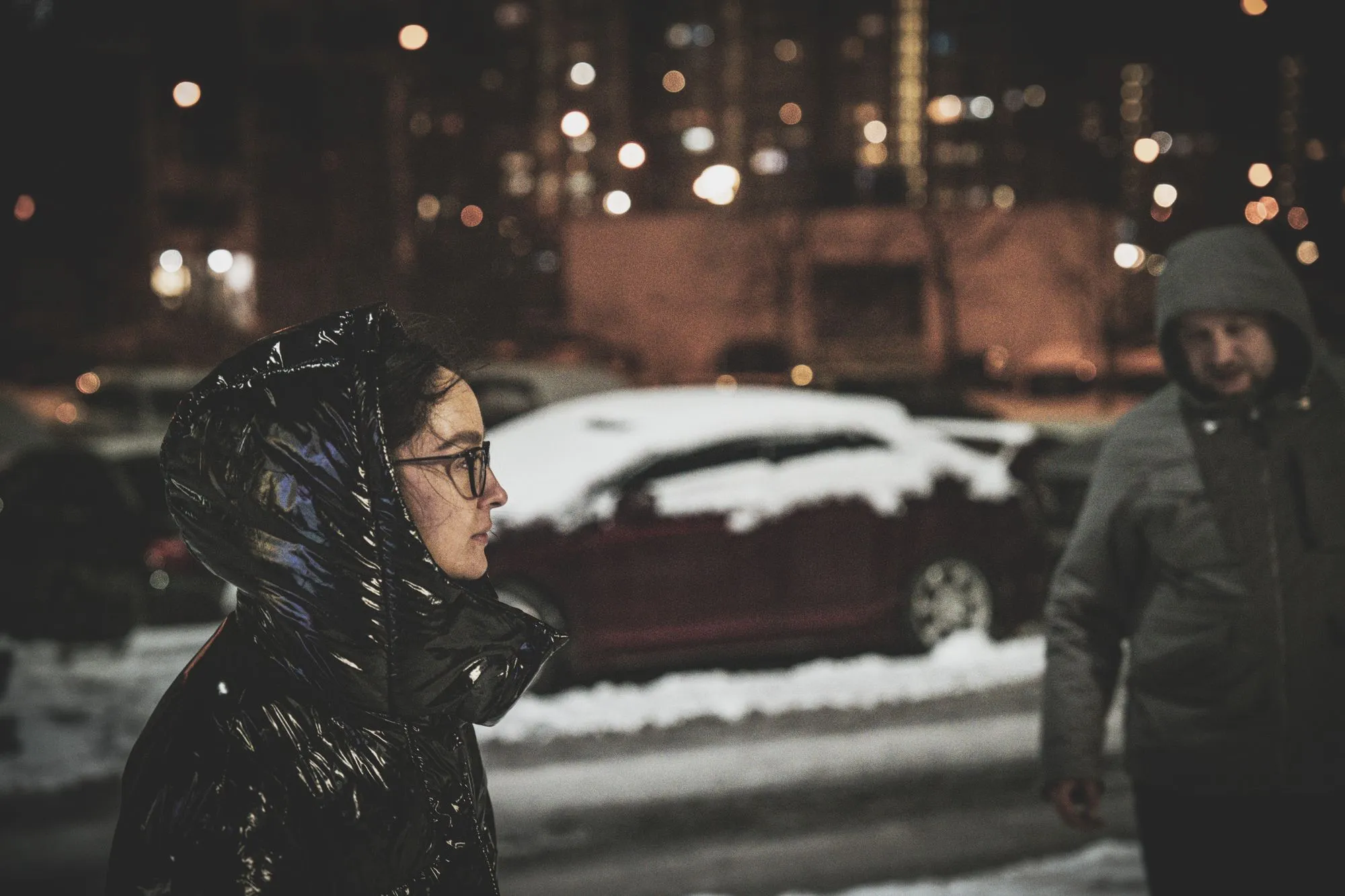 Two people in puffer jackets on a snowy street, standing in for the Halden Softshell Heated Jacket